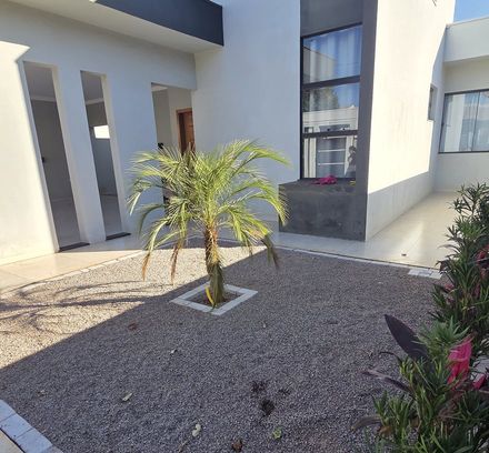 jardim frontal de pedrisco cinza com palmeira, antes da instalação